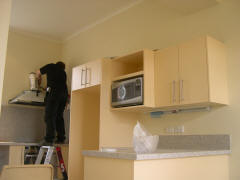 Microwave in place and space for the fridge to its left.